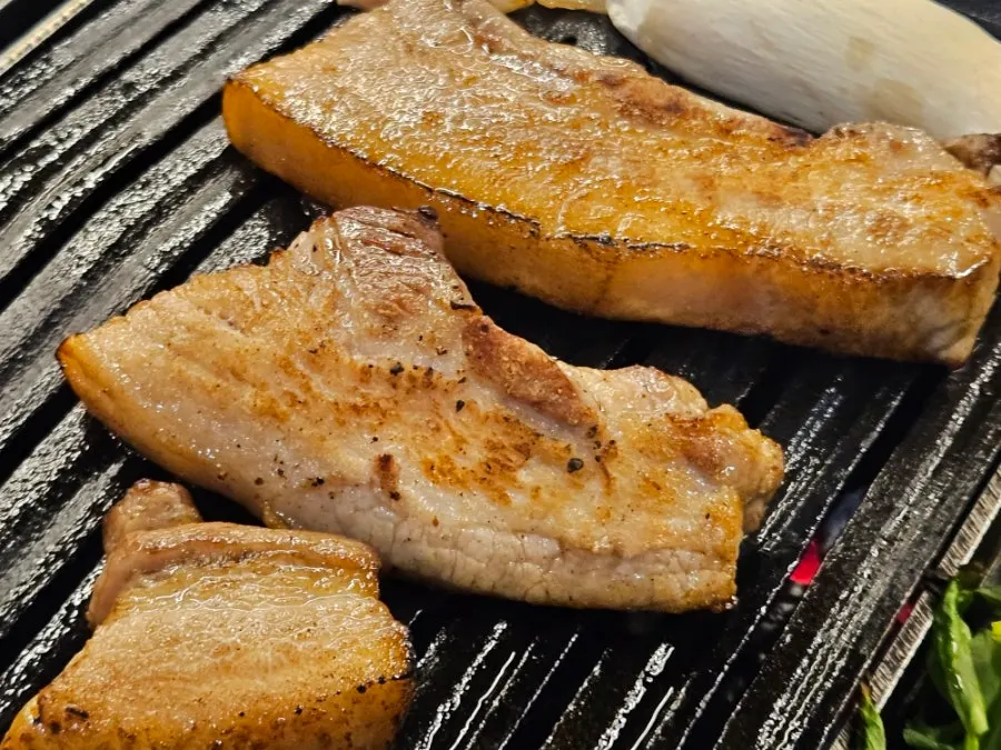 Pork belly with kimchi and minari on the special grill pan