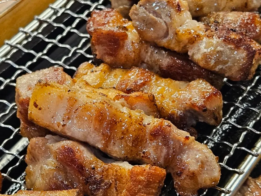A piece of pork belly wrapped with greens and sauce