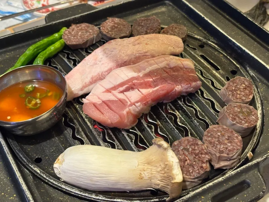 Raw cuts of garlic-marinated pork, seasoned pork neck, whole pork jowl, and black pork belly