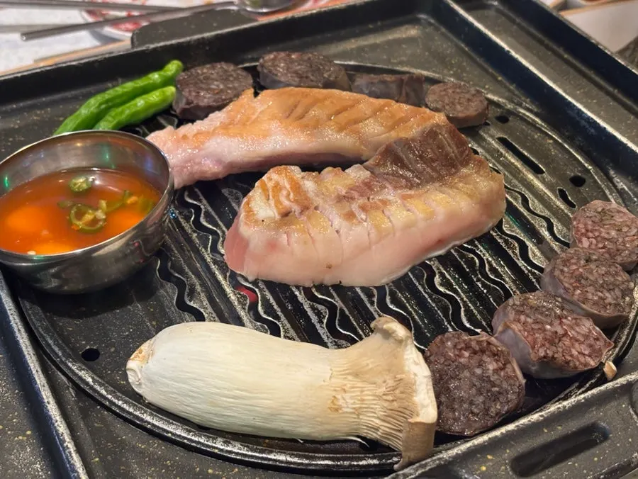 Grill with thick, scored black pork cooking