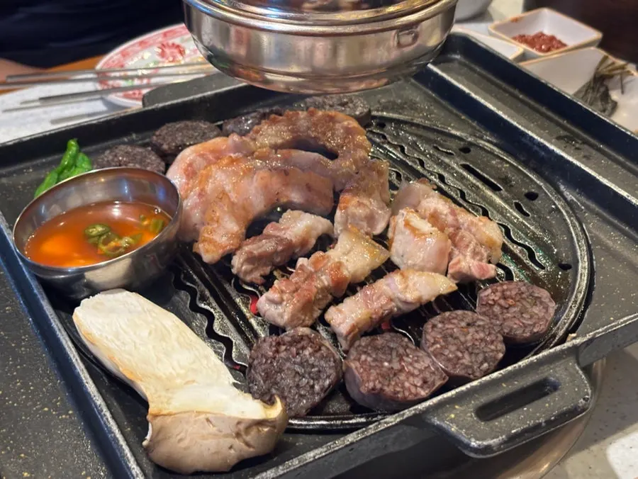 Close-up of several cuts of black pork grilling