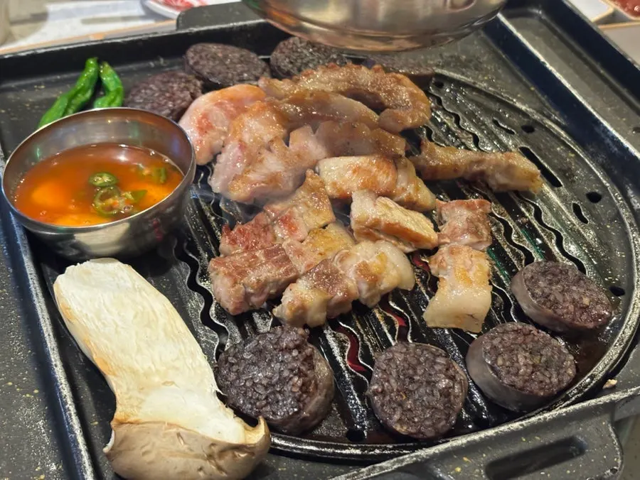 Grill with meat, sundae, and mushrooms all cooking together