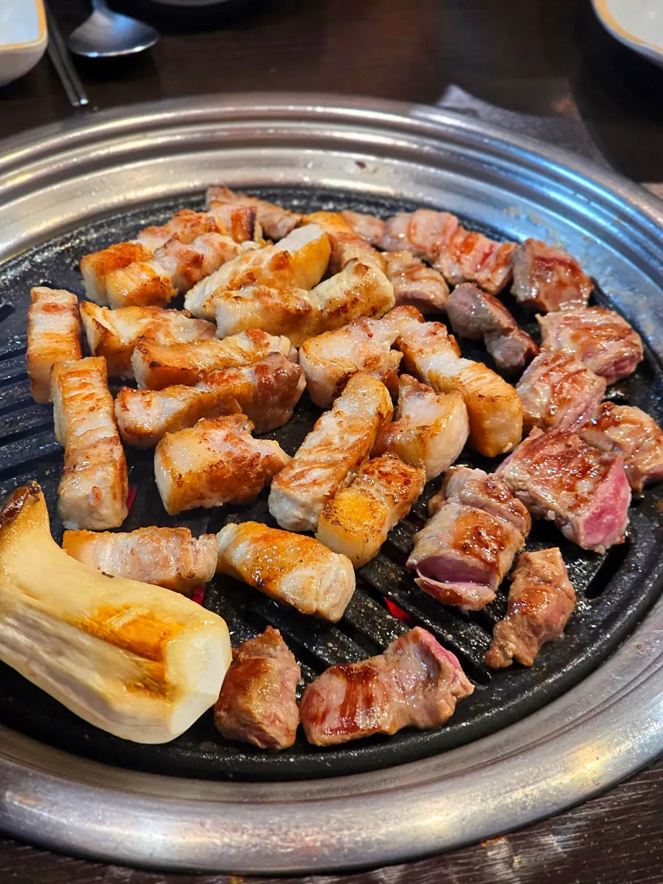 Staf sedang memanggang daging di atas arang