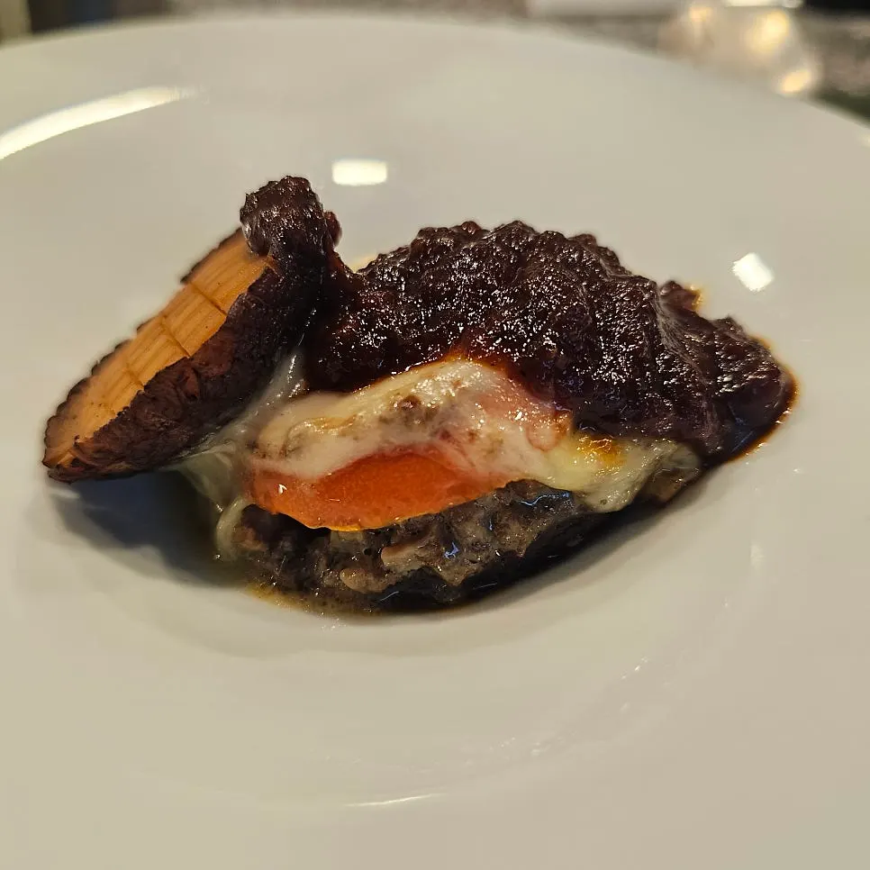 Cross-section of lasagna topped with mozzarella and smoky sauce