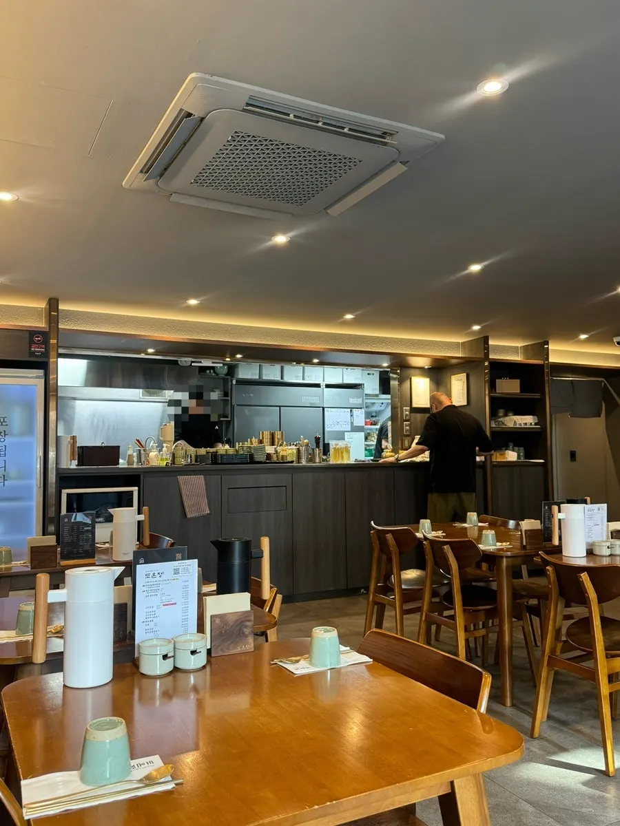 Ceiling with round recessed lighting and seating at Doonjeong