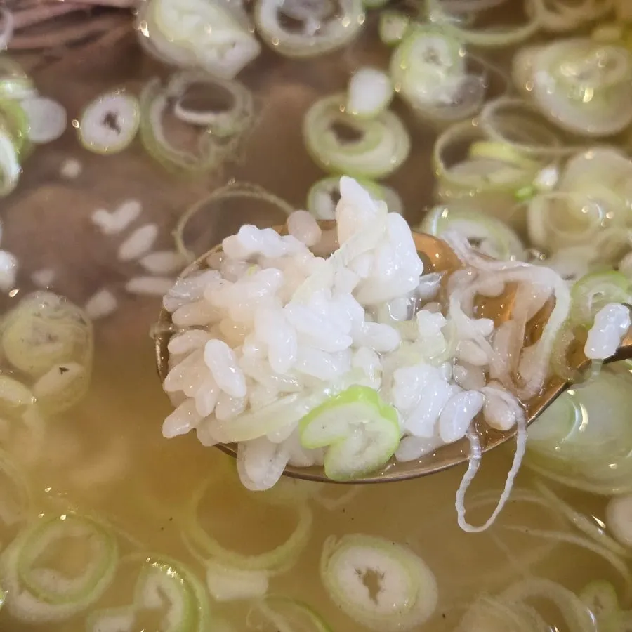 Clear gomtang broth topped with scallions