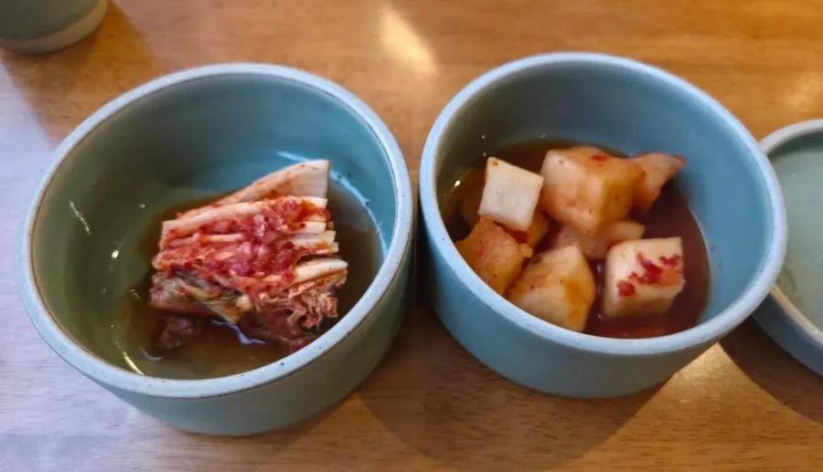 Napa cabbage kimchi and diced radish kimchi served first