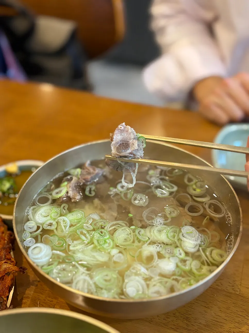 Sujigomtang broth served with side dishes
