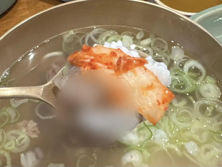 A spoonful of rice topped with meat and kimchi