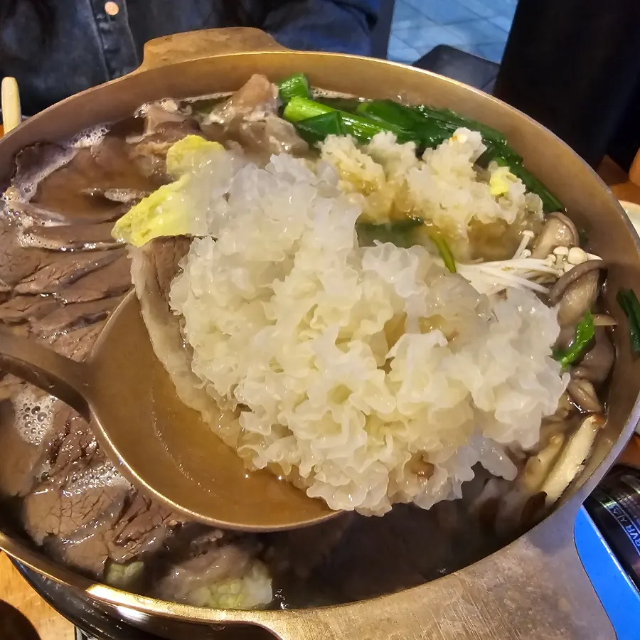 놋쇠 냄비에 담긴 소고기와 백목이버섯