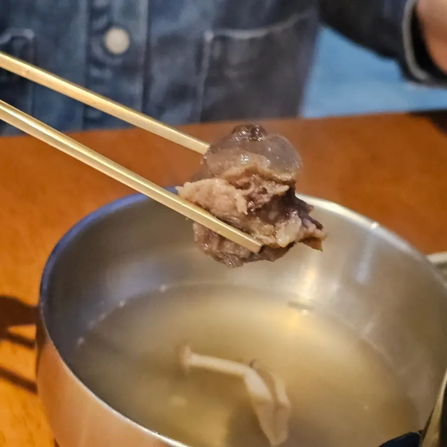주전자로 맑은 육수를 붓는 한우전골