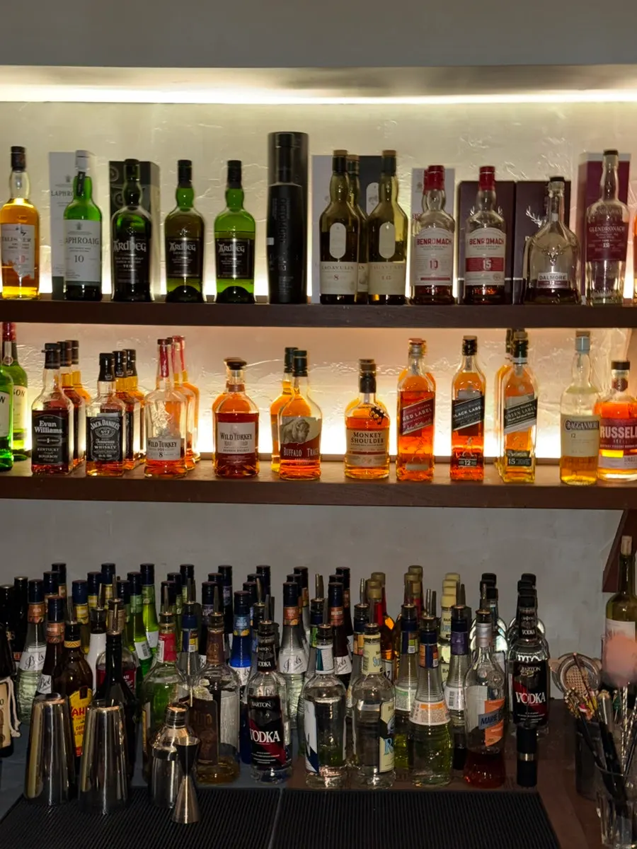 Whiskies and liquor lineup displayed on the bar shelf