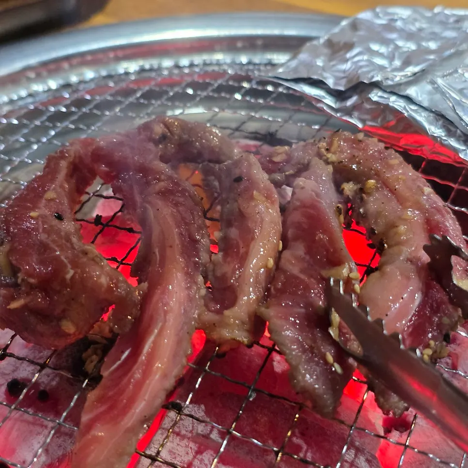 Marinated garlic short ribs placed on the charcoal grate