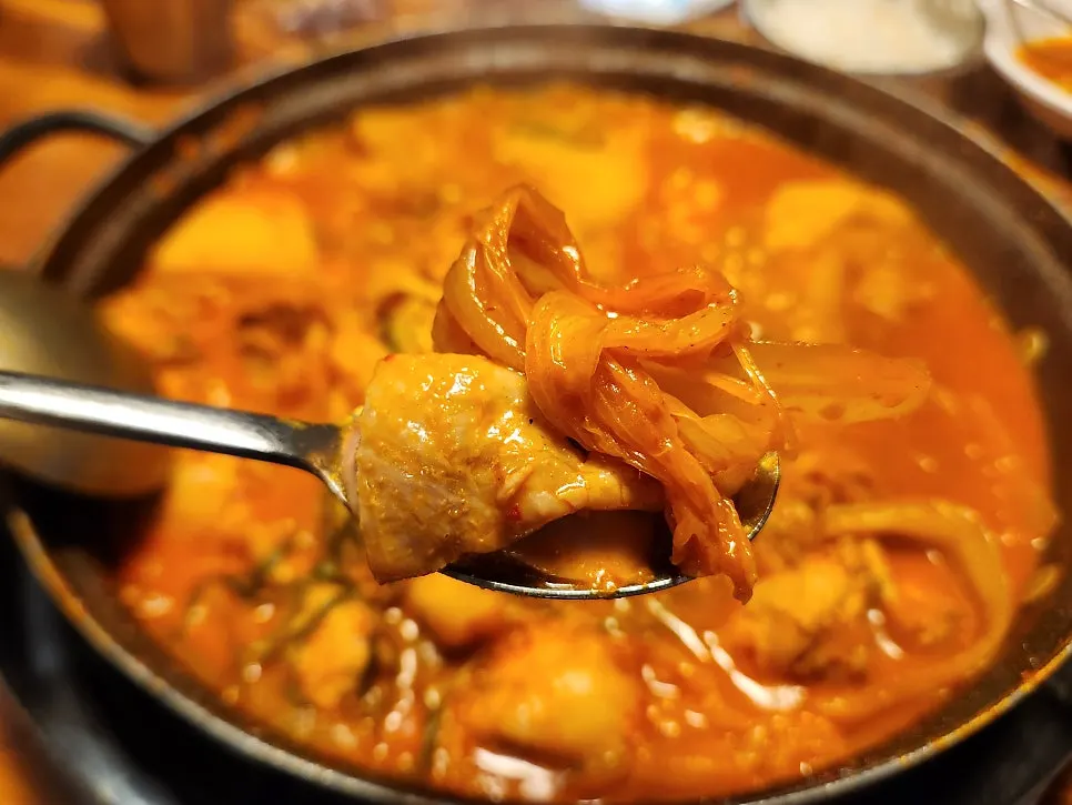 A piece of dakdoritang wrapped in aged kimchi