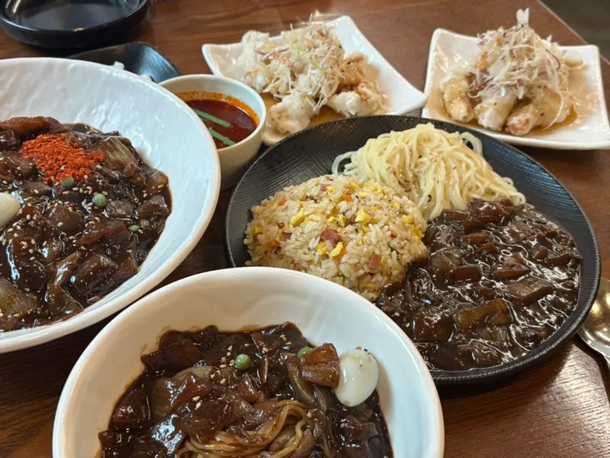 Table spread with spicy jjajang set, fried rice set, and kids' jjajang