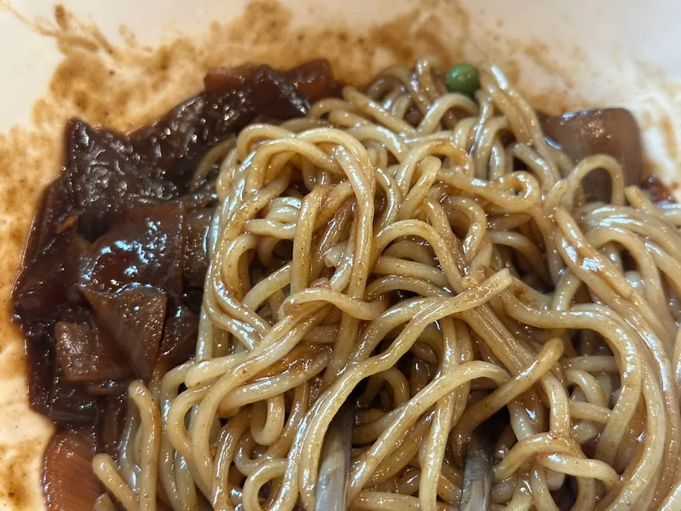 Jjajangmyeon made with house-made noodles, lifted with chopsticks