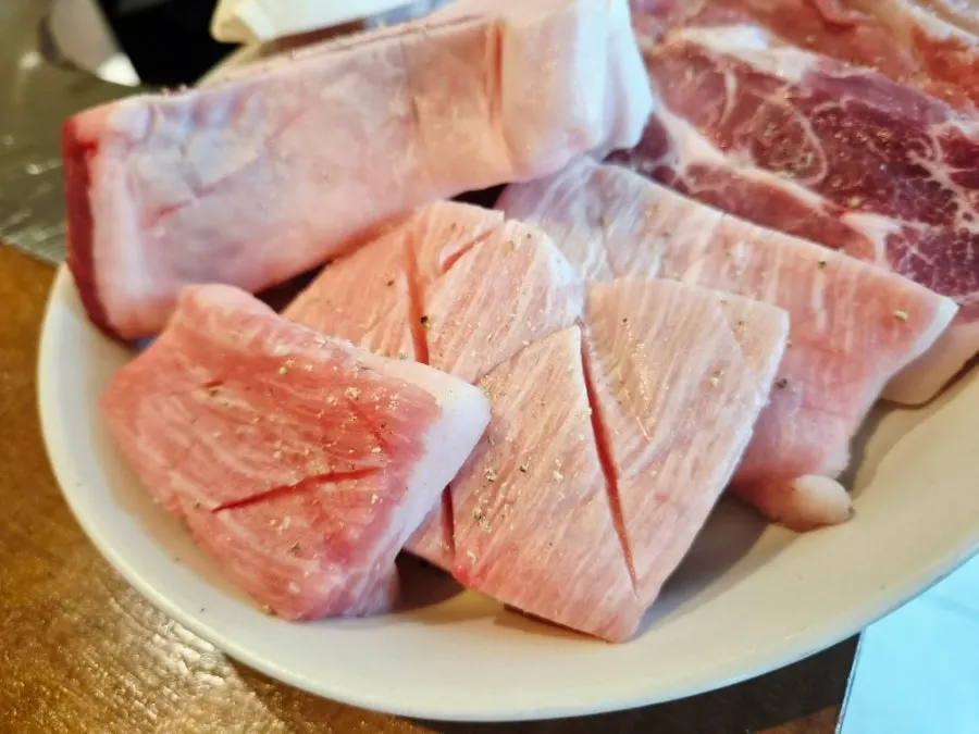 가루 뿌려진 숙성 돼지고기 접시