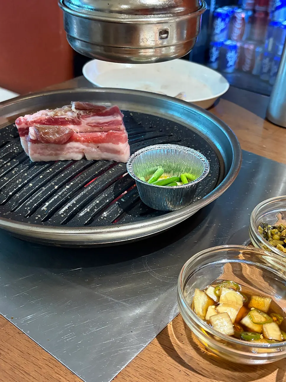 불판 위에서 구워지는 고기와 반찬 상차림