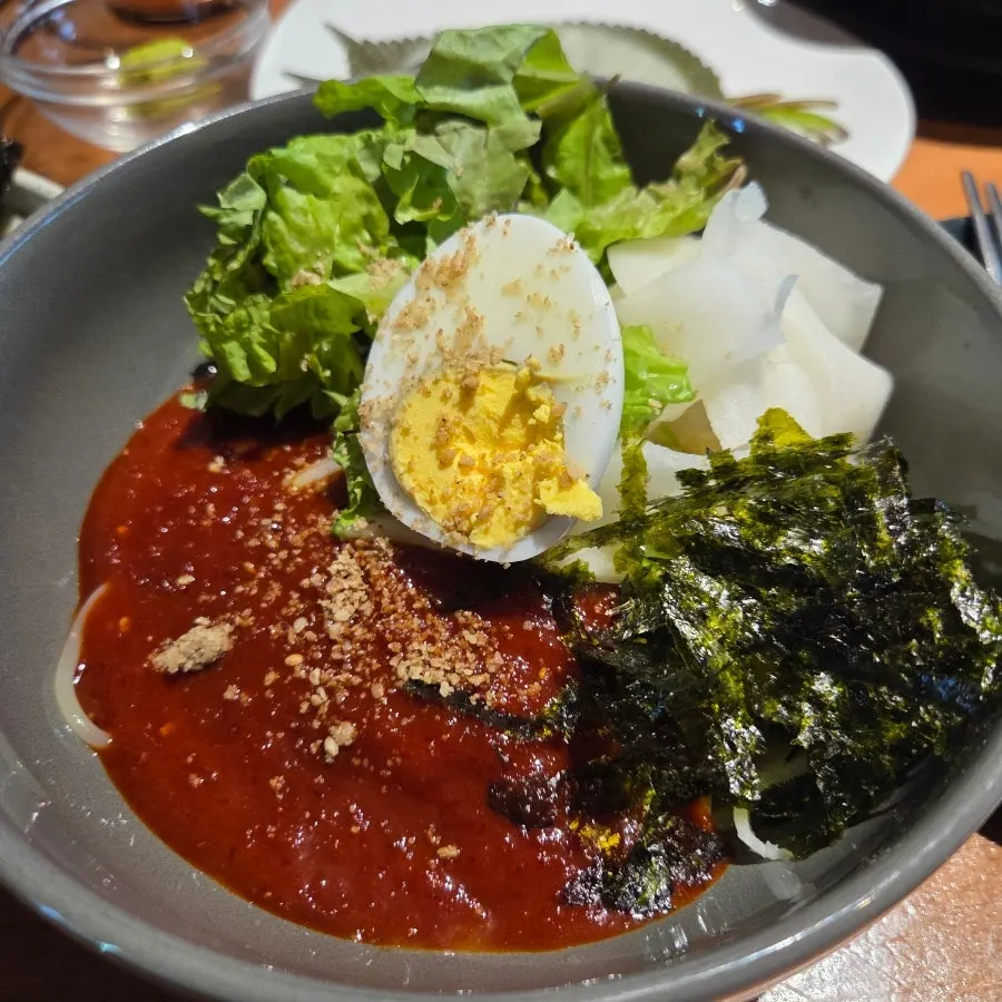 Bibim jjolmyeon and steamed egg side dishes at Dot Osong