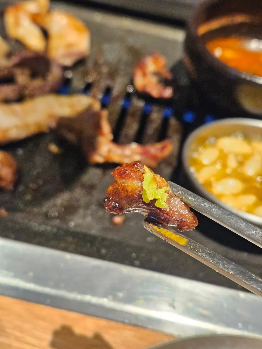 A grilled piece of meat dipped in myeoljeot sauce