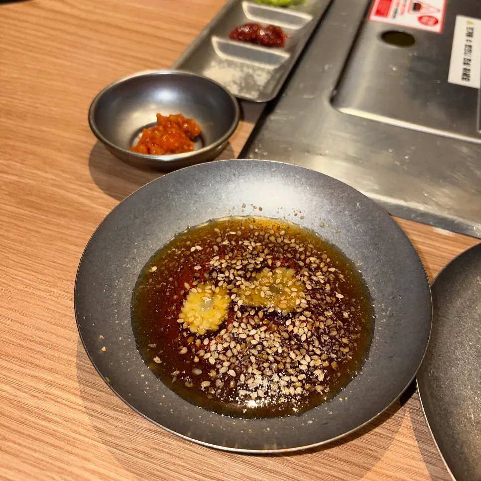A piece of grilled meat with olive kimchi at Dotdot