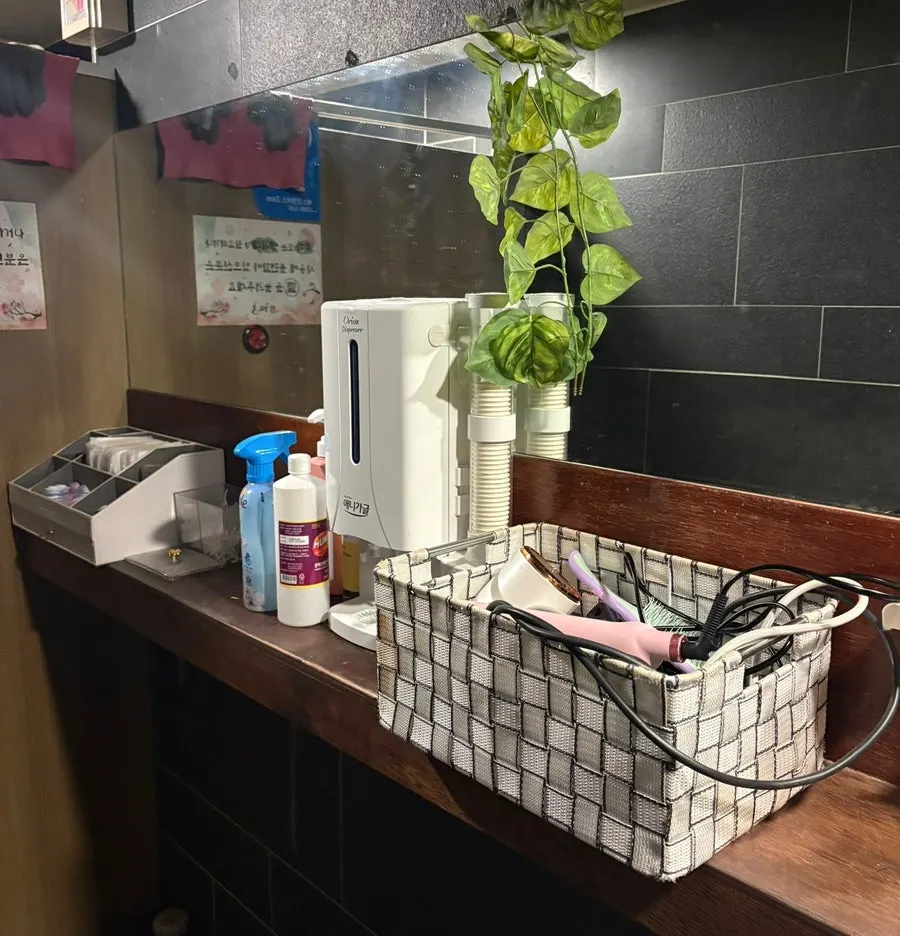 Women's restroom powder area stocked with amenities