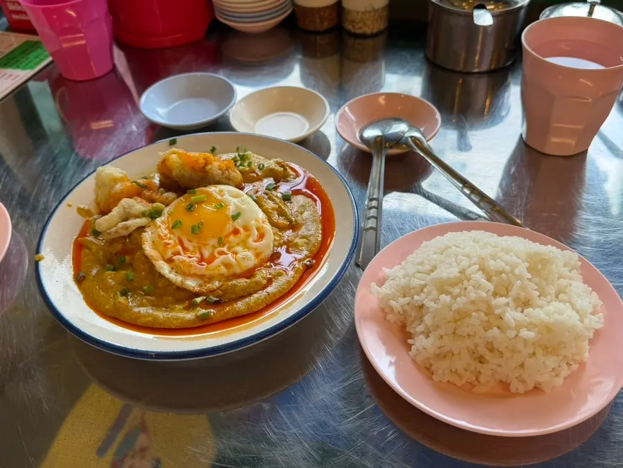 Close-up of poo pad pong curry topped with fried crab meat