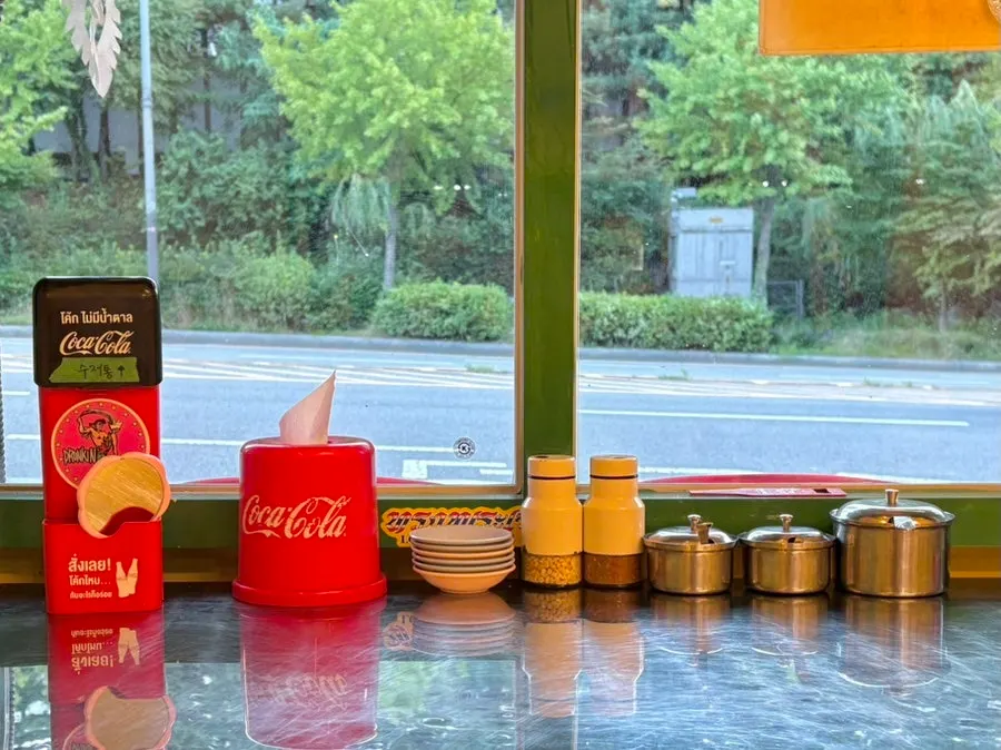 Condiments set out on the table, including peanuts, chili peppers, and pickled radish