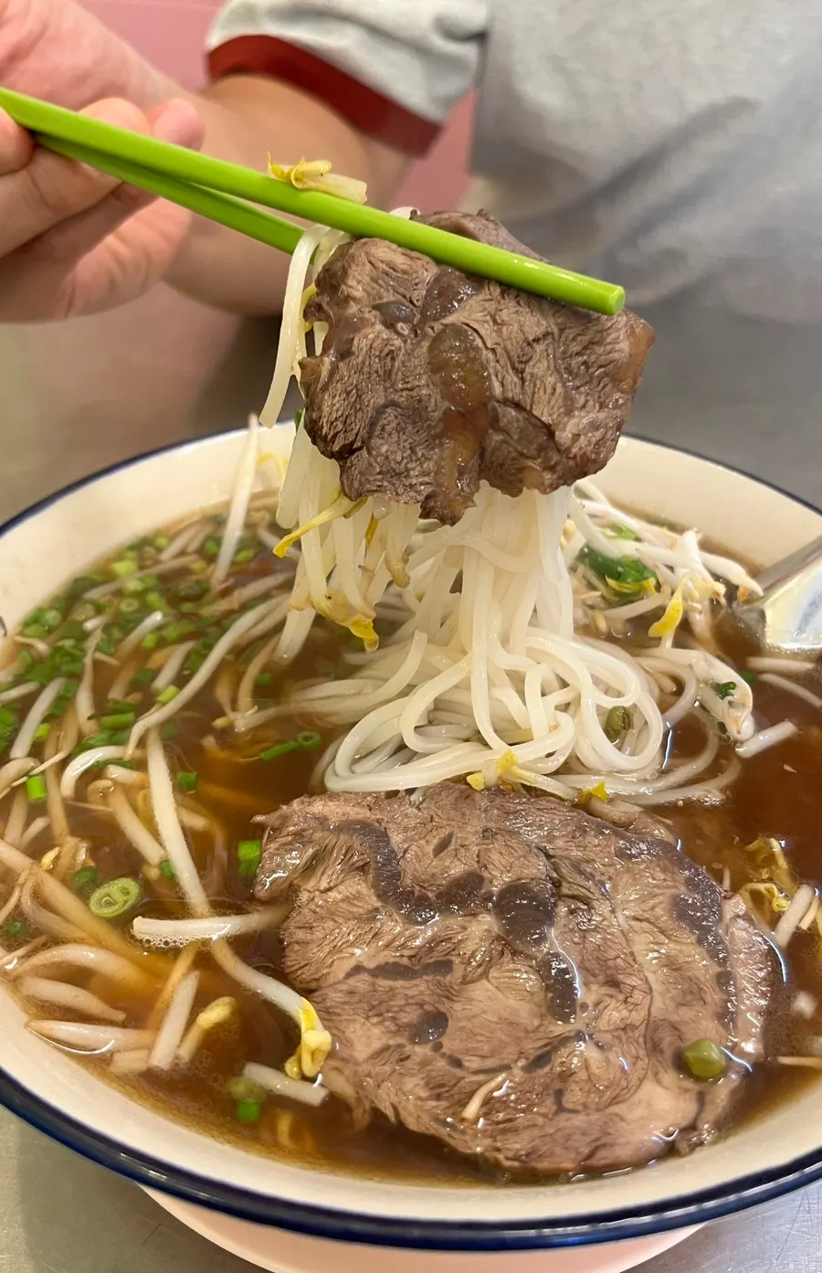 Pho topped with bean sprouts and thick beef slices