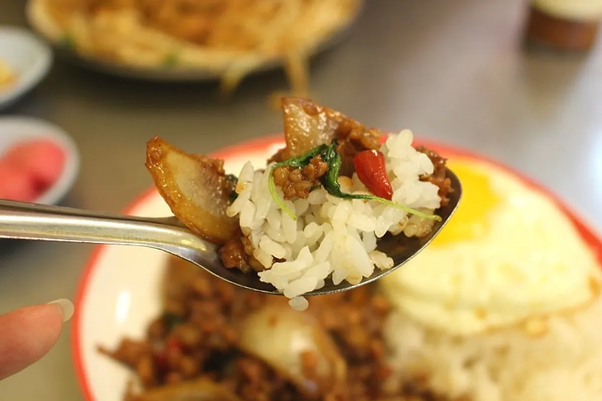 A bite of pad thai lifted with chopsticks