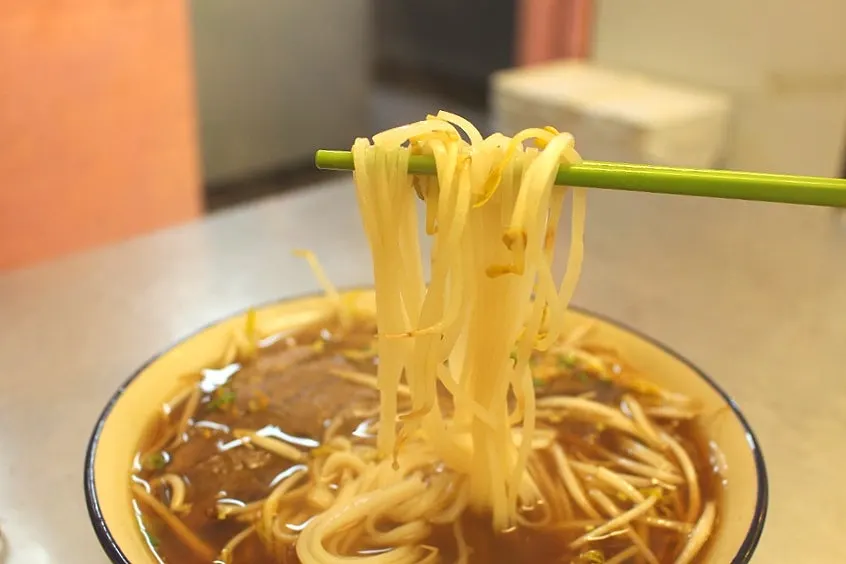 Rice noodle soup topped with thick meat slices and bean sprouts
