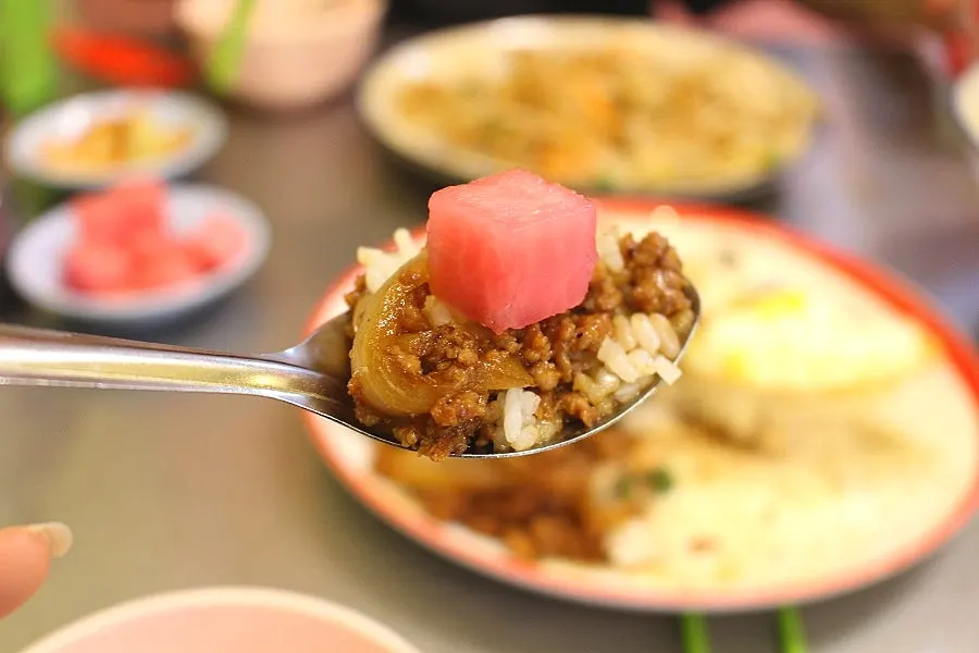 A spoonful of khao pad mixed with minced vegetables