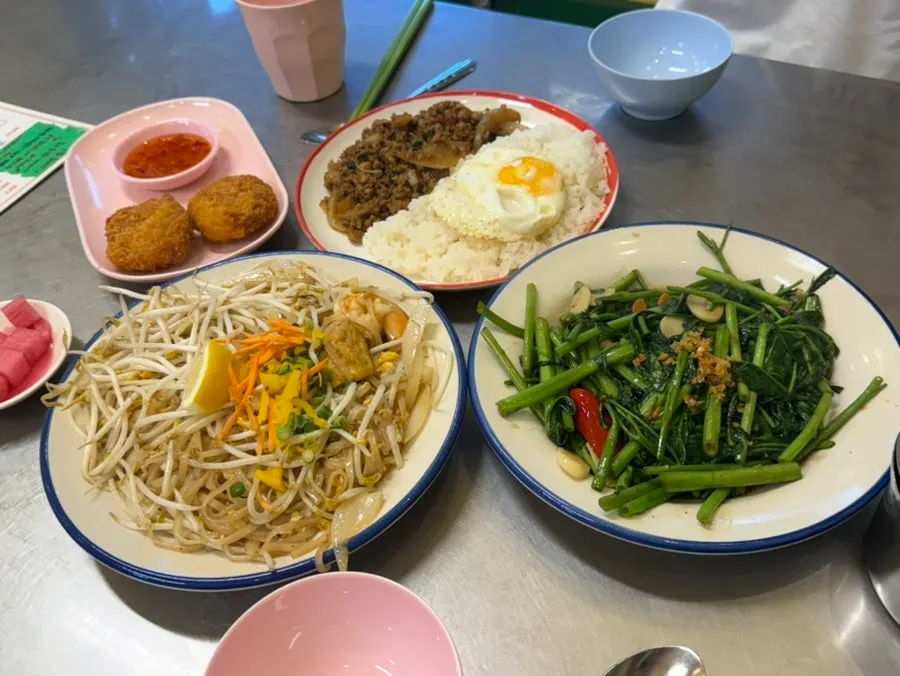 Pad thai and pad kra pao moo saap on the table