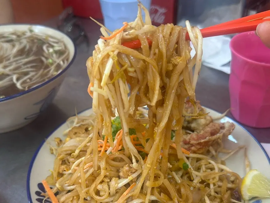 夾起泰式炒河粉麵條的畫面
