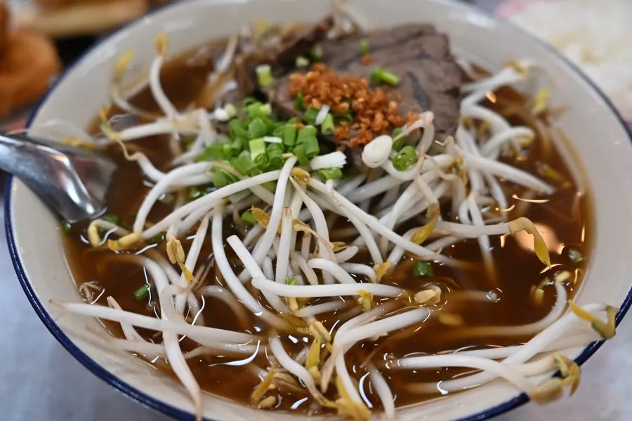 Pho topped with thick slices of beef and bean sprouts