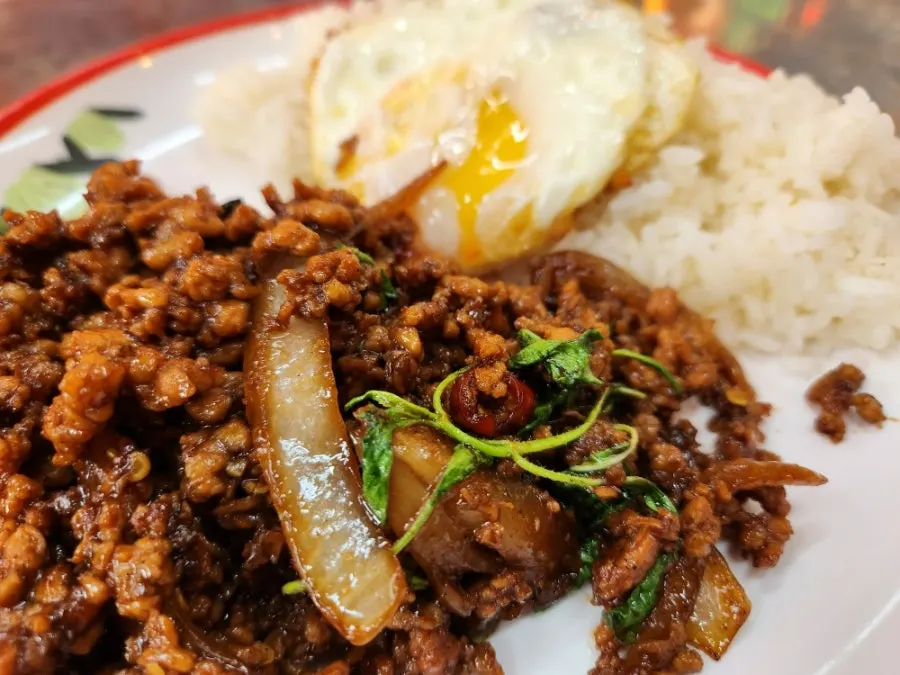 Pad kra pao moo sap served over rice with a fried egg