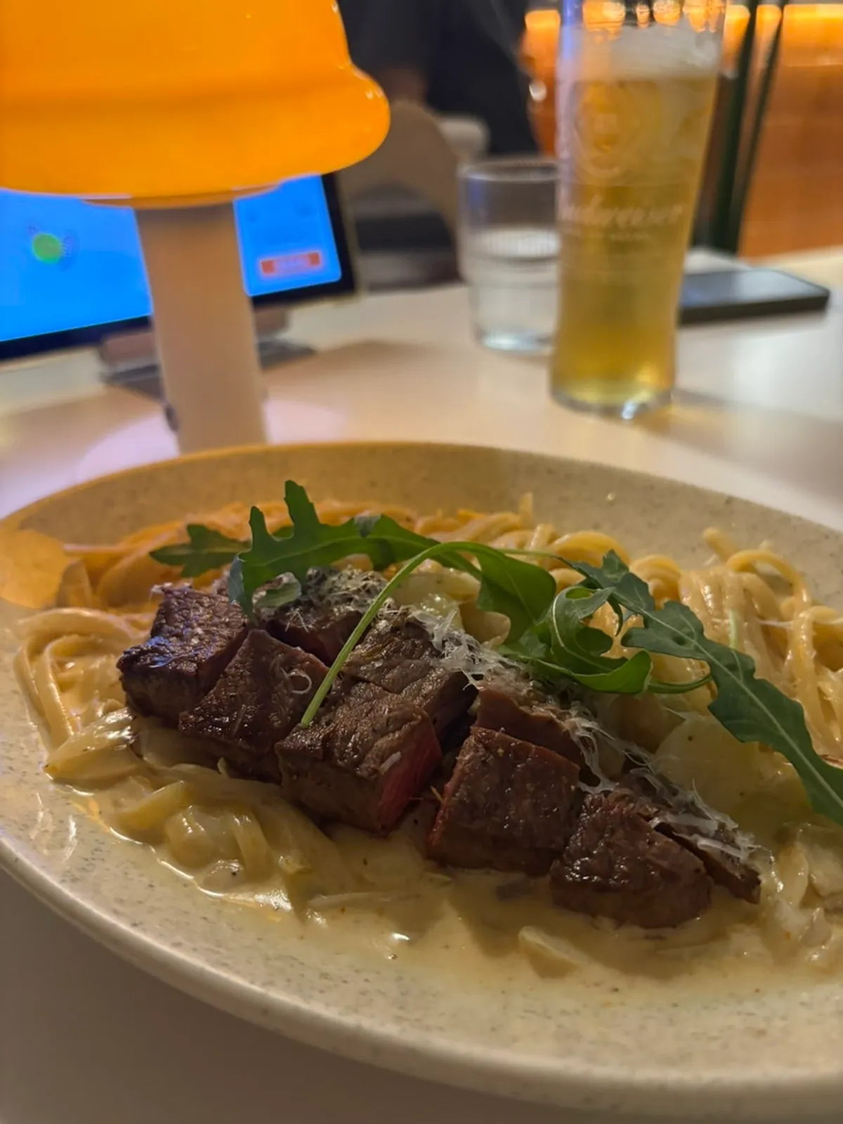 Steak cream pasta topped with cubed steak