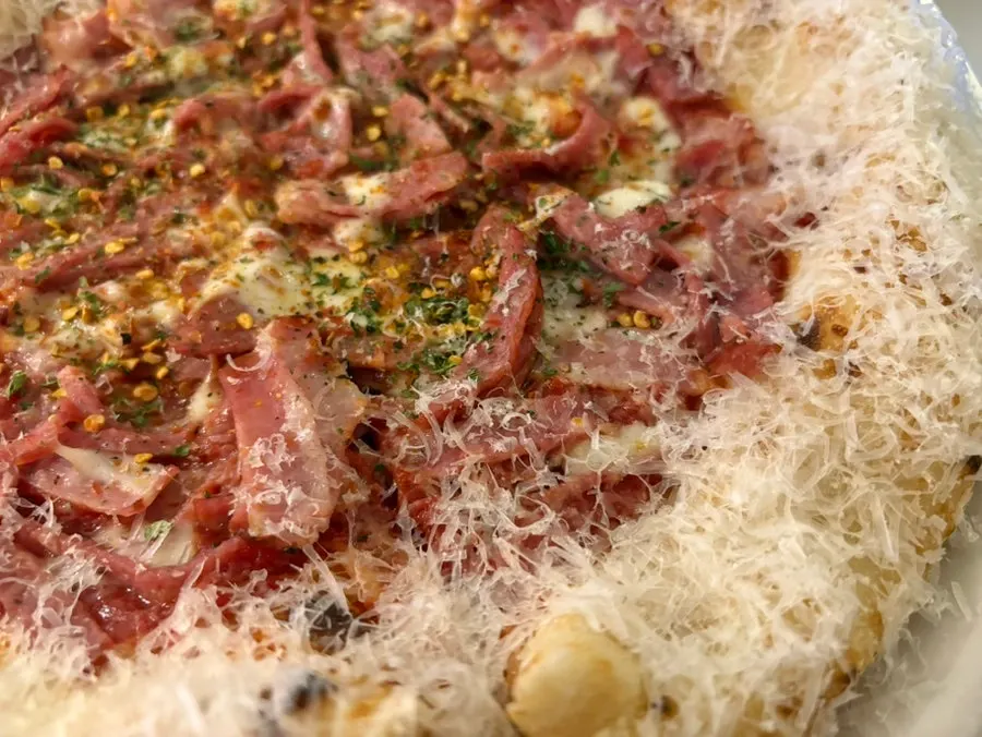 Slice of diavola pizza with cheese along the crust