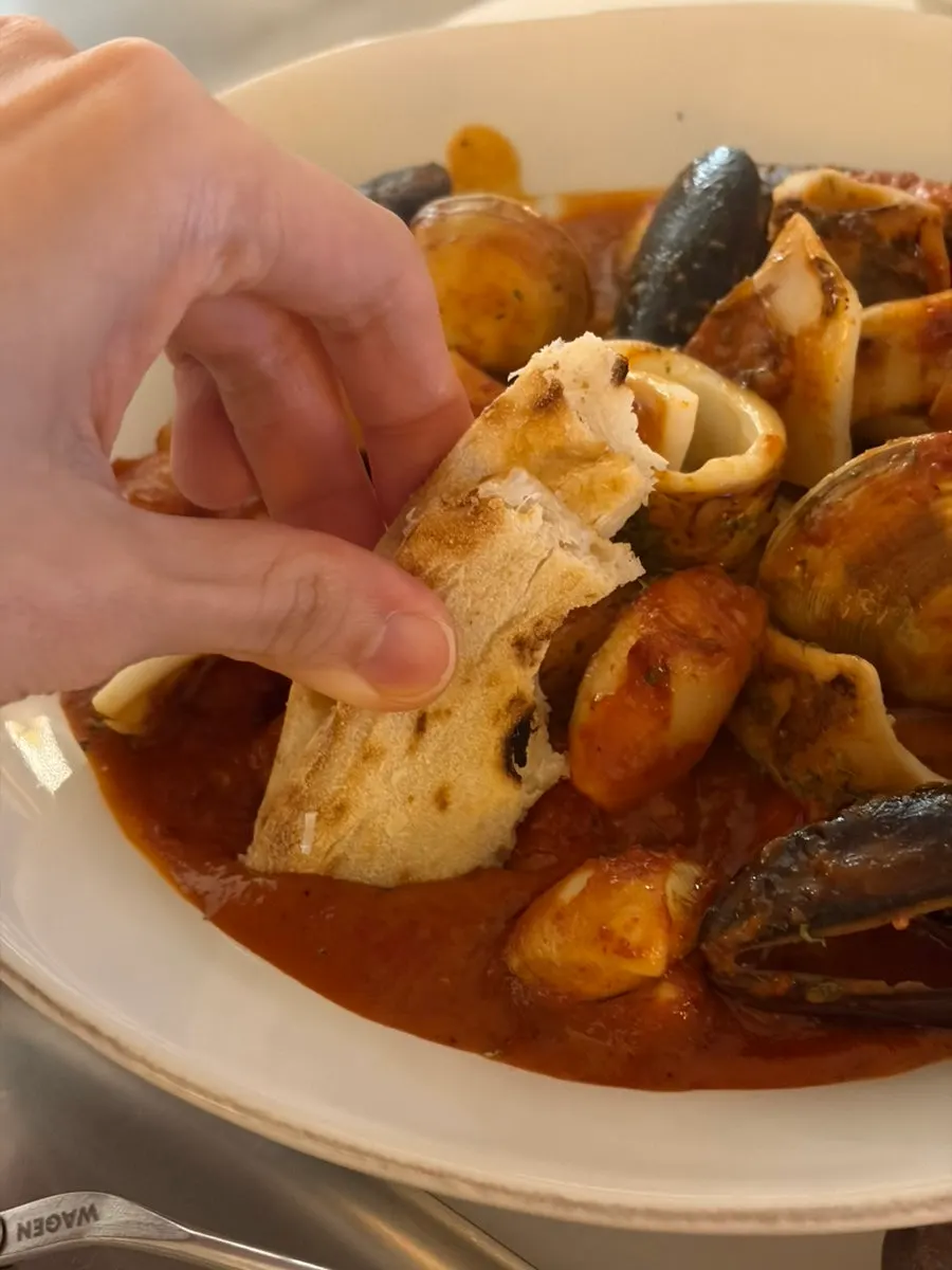 Dipping pizza dough into the tteokbokki sauce