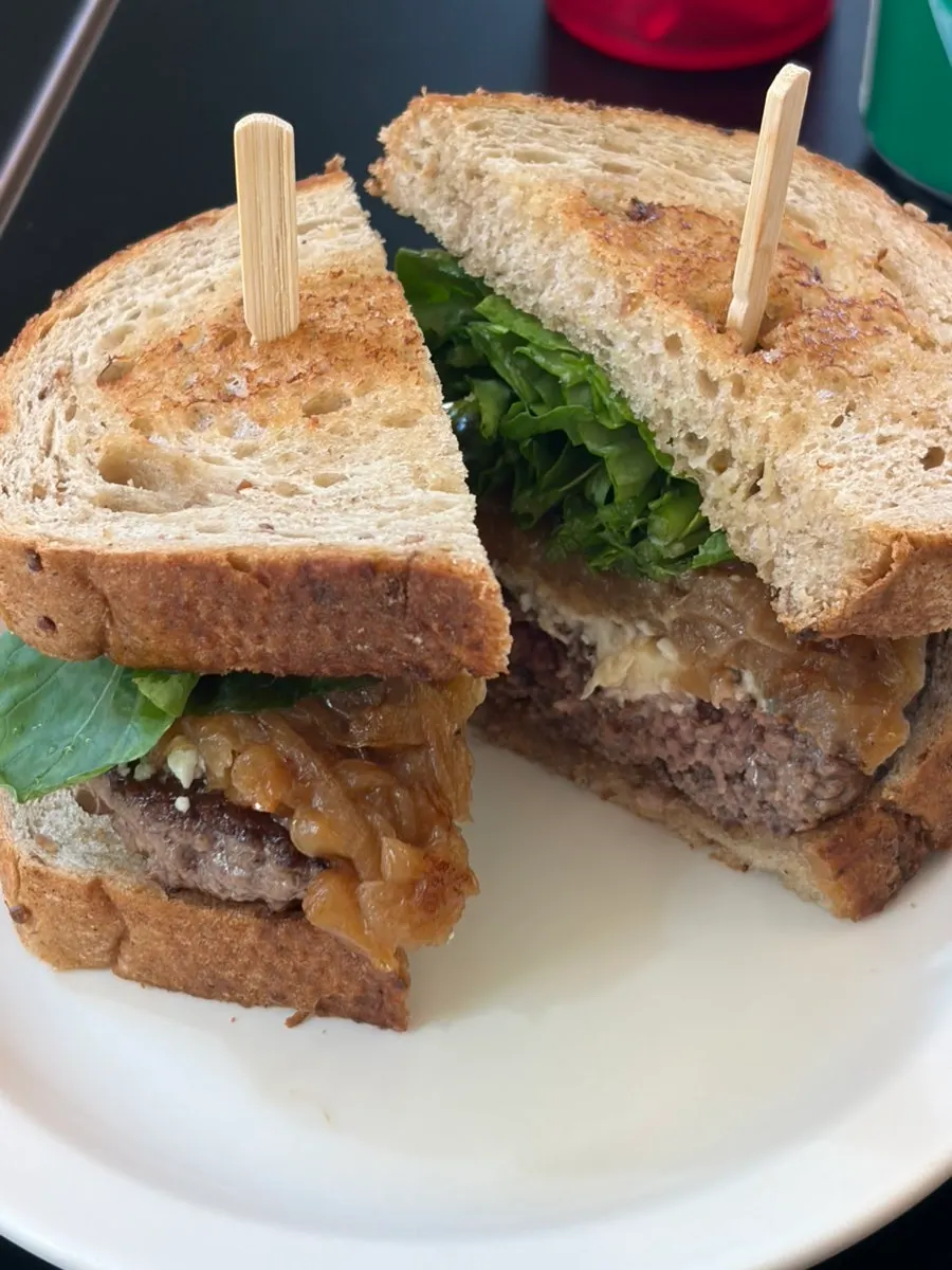 Blue cheese arugula burger topped with arugula