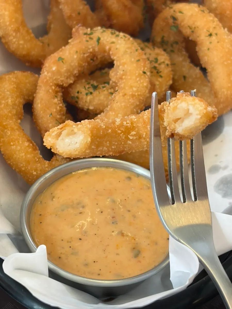Dipping sauce served alongside the onion rings