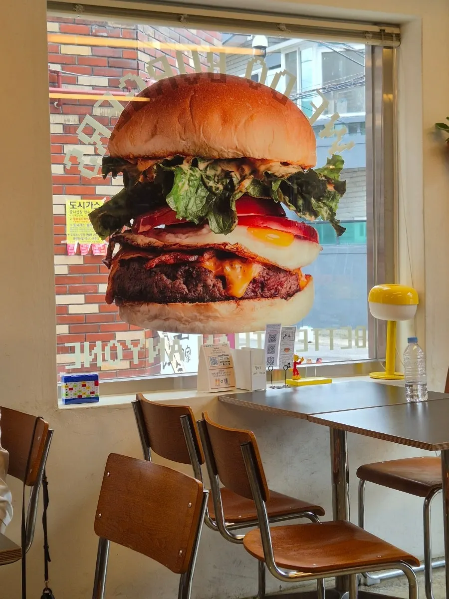 Menu board listing burgers, toppings, and sides