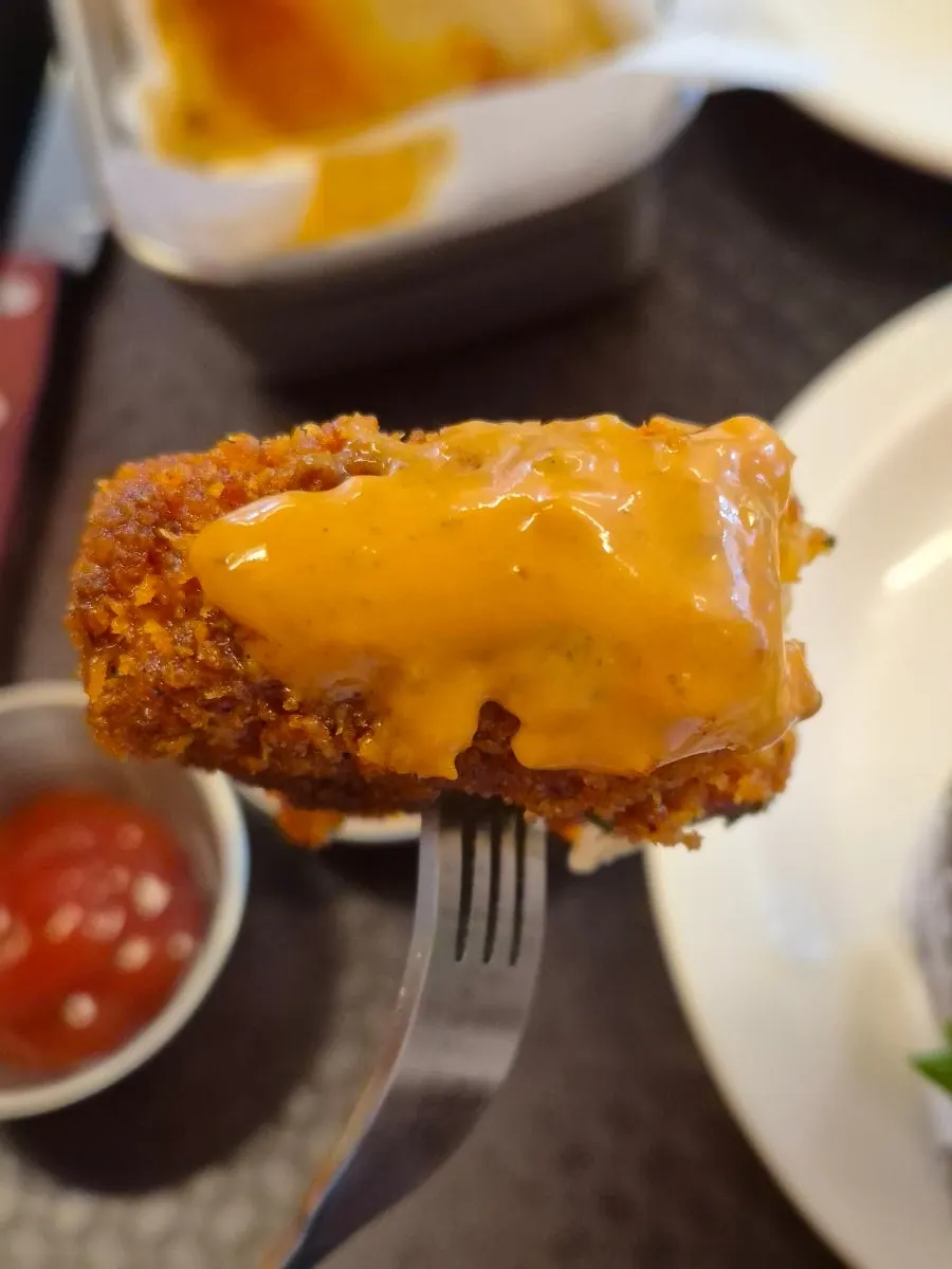 Mozzarella cheese sticks split open with melted cheese stretching out