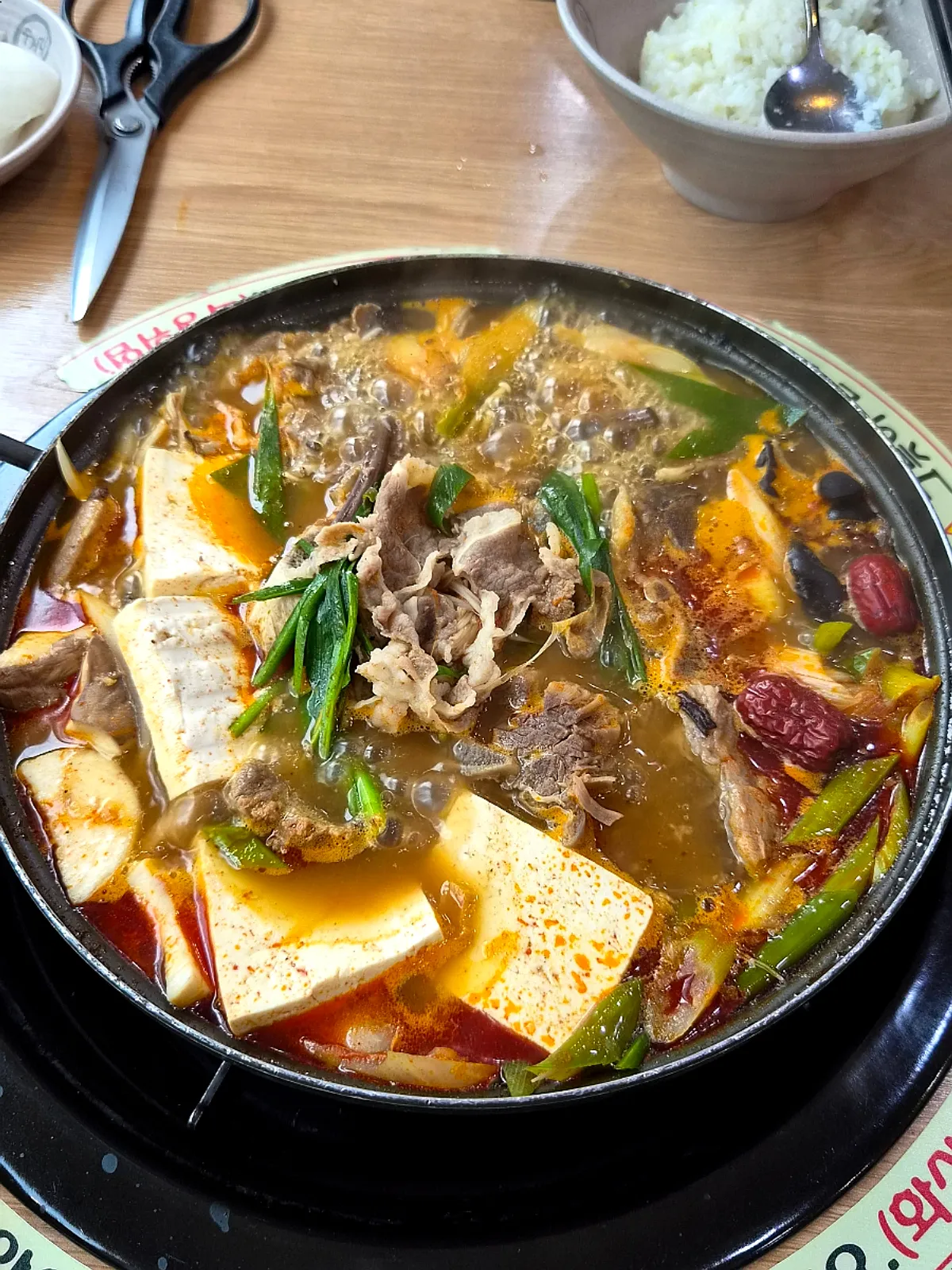 A bowl scooped with broth and beef from the teukjeon-gol