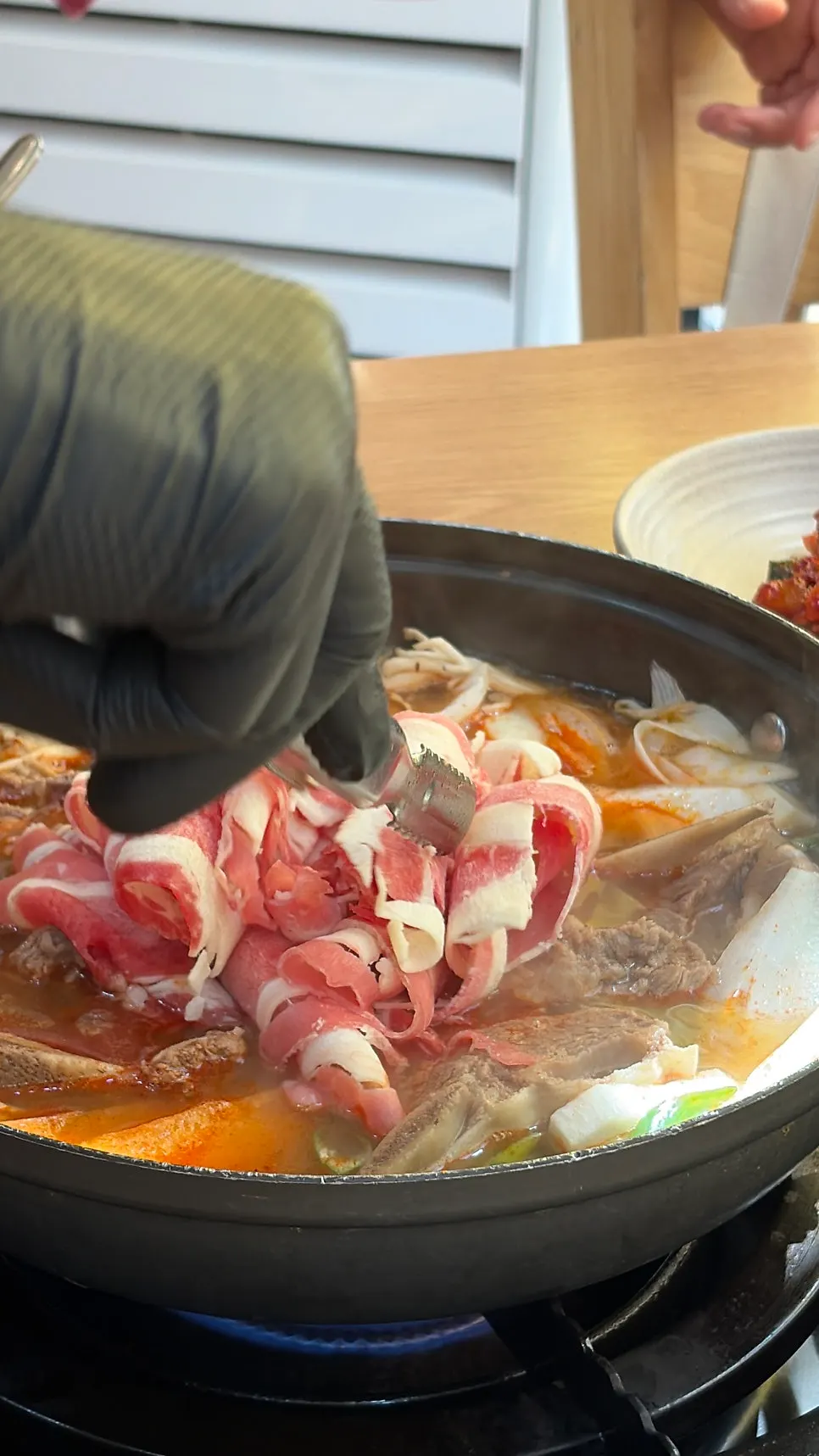 Beef cooking in the spicy usinjeongol broth