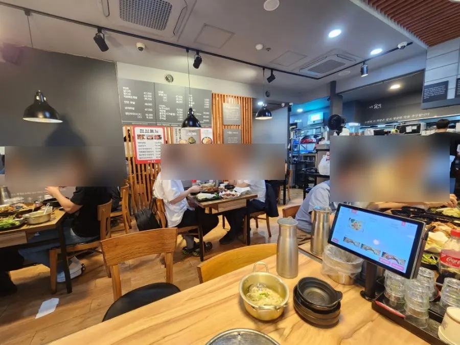 점심시간 손님이 있는 더족발 매장 내부와 테이블