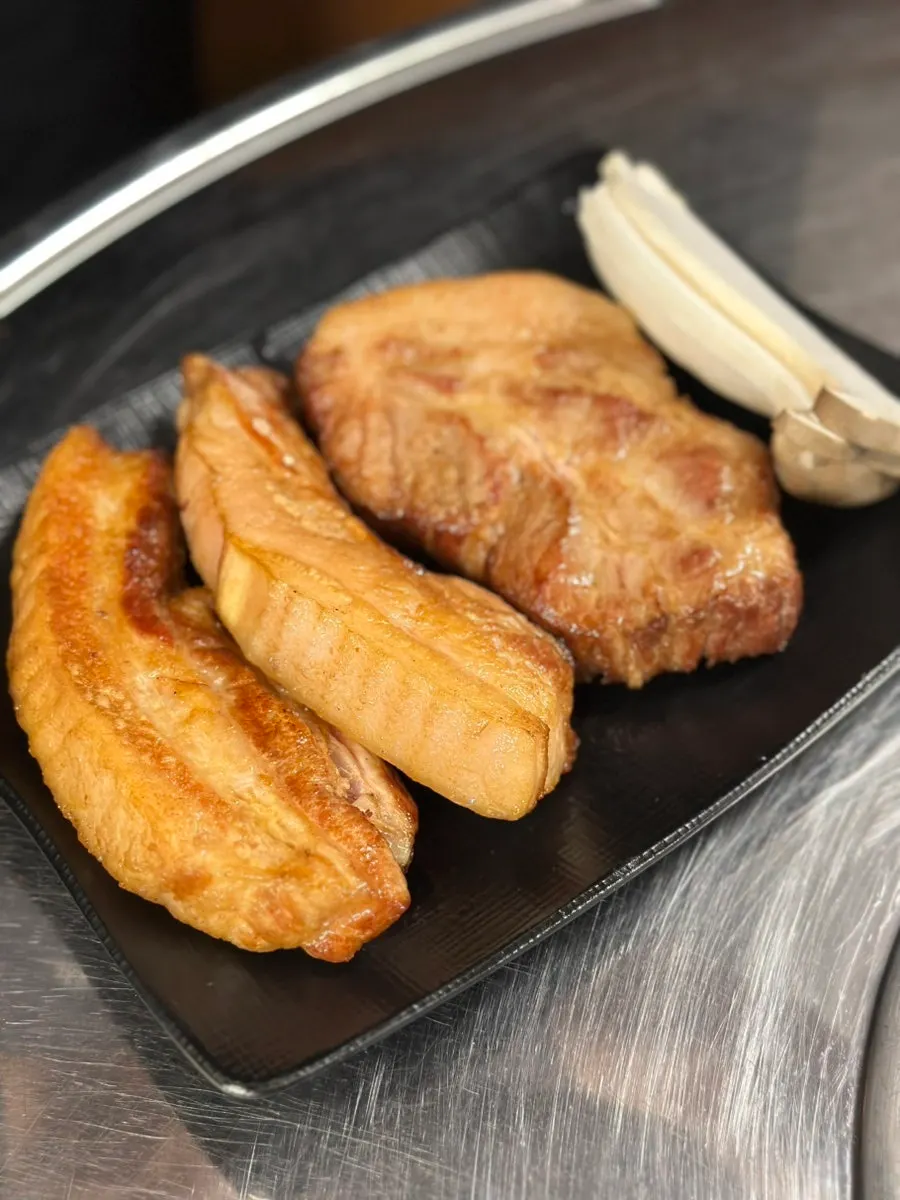 Pre-seared pork neck and pork belly on the grill