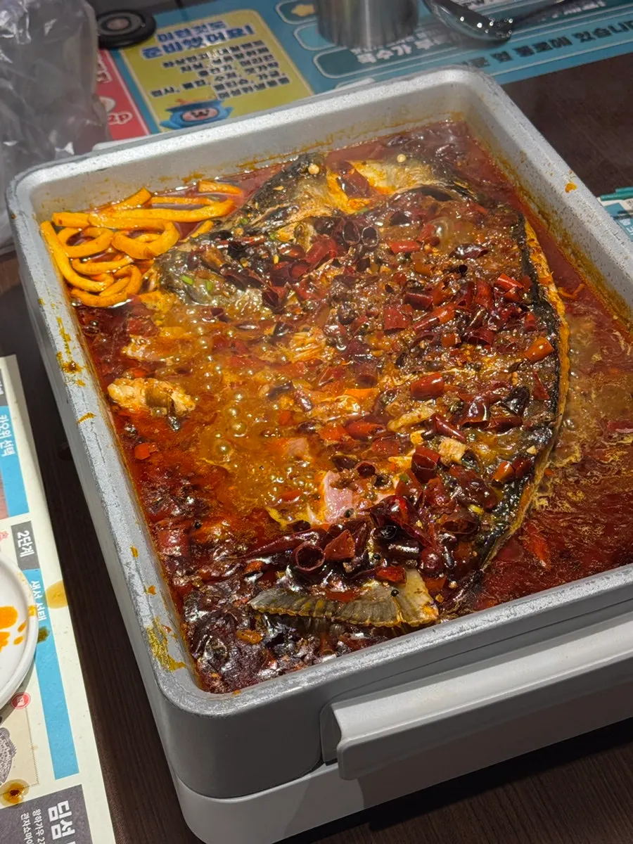 A piece of kaoyu fish being lifted with chopsticks