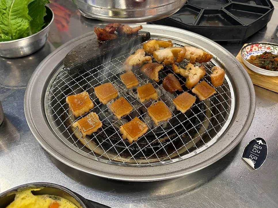 Pork skin and pork tail grilling on a wire grill pan