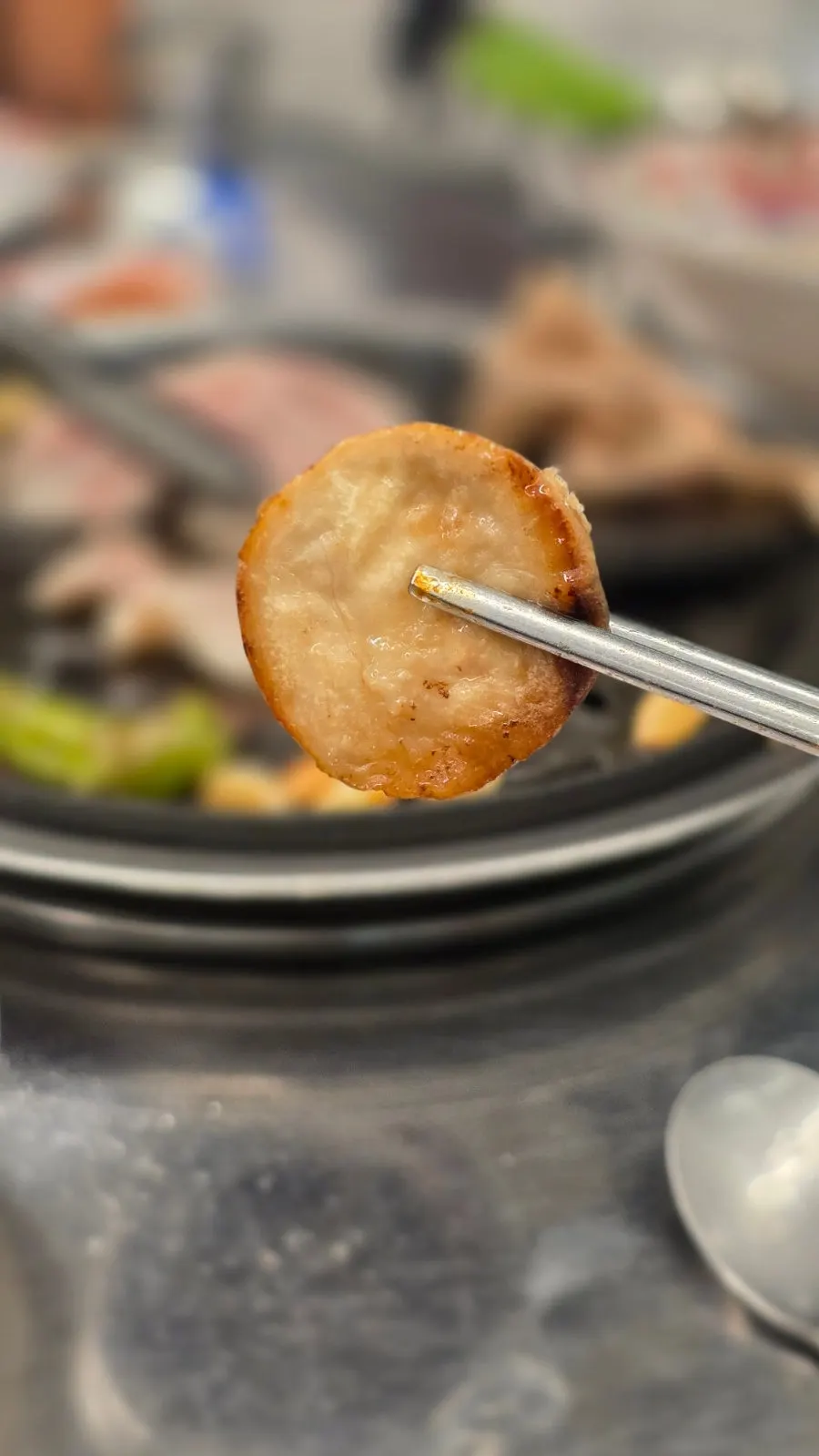 A single grilled slice of pork belly shown upright